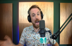A man wearing headphones works in a recording studio, focused on sound equipment, representing the Adobe Audition Online Course.