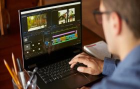 A man focuses on his laptop, editing content with a video editing program, representing the Adobe Premiere Pro Online Course.