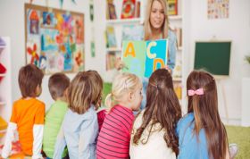 Female teacher instructing students, representing CACHE Level 2 Certificate in Caring for Children & Young People course.