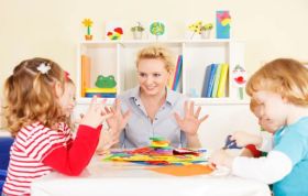 Woman guiding children in crafts, representing the CACHE Level 4 Certificate for the Early Years Advanced Practitioner course with hands-on learning.