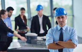 A man in a hard hat discusses safety at a construction site, representing the Certified Associate in Project Management Online course.