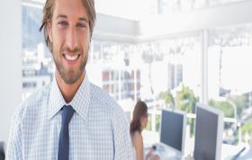Well-dressed man with woman working on computer in background, representing Blockchain Solutions Architect course on Blockchain basics.