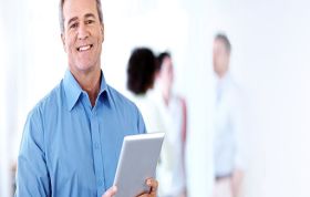 Employee in blue shirt focused on tablet, representing the Certified Information Systems Auditor CISA course for audit and IT compliance skills.