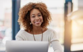 Smiling woman with curly hair, showcasing her joyful personality, representing the Cisco CCENT Course for foundational networking skills.