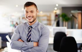 Man in shirt and tie smiling confidently, representing the Cisco CCNA (ICND2) with Practice Lab course for advanced networking skills.