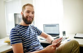 Smiling man with beard in blue shirt, representing the Cisco CCNP Troubleshoot course for advanced network troubleshooting skills.