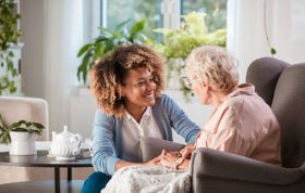 A woman discusses with an elderly woman, highlighting care and communication in the Complaints Handling Online Course.