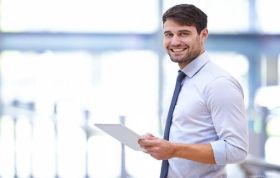 Smiling employee holding papers, representing Designing Database Solutions for Microsoft SQL Server 2012 Online Course.