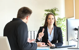 A man and woman in business attire discuss professionally, representing the Discipline and Grievance Online Course.