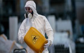 Man wearing PPE near caution material, emphasizing hazards in workplaces and handling hazardous substances in the DSEAR Online course.