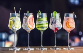 Elegant gin cocktails with garnishes on a dark table, representing the Gin and The Perfect Pairing Online Course.