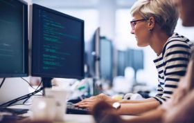 A woman works on a computer, using a software program, representing the Google Cloud Platform (GCP) Online Course.