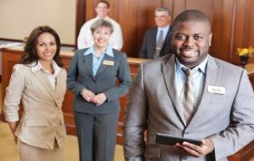 Group of hospitality professionals in hotel lobby, representing Guest Excellence and high standards in the hospitality sector.