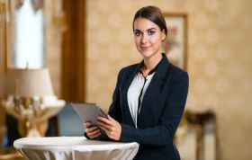 Well-dressed hospitality professional with tablet, representing Guest Recovery and effective solutions in the hospitality sector.