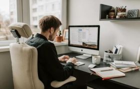 Man working at computer desk, highlighting Home Working Health & Safety and potential risks associated with working at home.