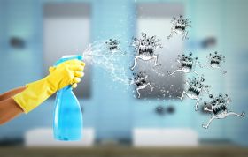 Person wearing rubber gloves spraying a blue bottle, representing the Infection Prevention & Control for Non-Clinical Staff Online course.