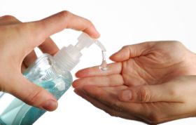 Person holding a bottle of hand sanitizer, representing the Infection Prevention and Control course for promoting hygiene practices.