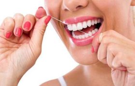 Woman using dental floss for hygiene, representing Oral Care as an essential part of health care in the Introduction to Oral Care Course.