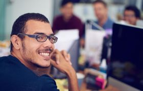 Man with glasses smiles warmly at the camera, representing the IT Technician Career Bundle course with a friendly, approachable vibe.