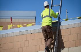 Construction worker climbing ladder, highlighting Ladder Safety and essential checks to perform before using a ladder.