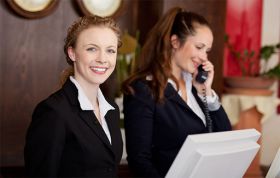 Two professionally dressed women working at front desk, representing Leading Great Shifts and managing shifts with confidence and skill.