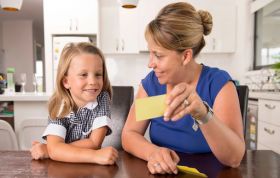 Woman and child examine a yellow paper together, representing the Learning Disability Awareness Online course.