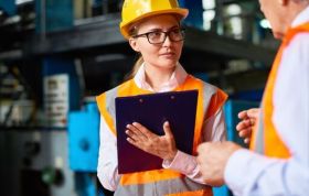 Two persons in hard hats discussing in an industrial setting, representing the Level 3 Health and Safety Online Course.