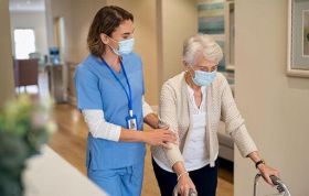 Female medical staff caring for disabled elderly woman, highlighting Infection Control in a care establishment for Level 3 Infection Control Course.