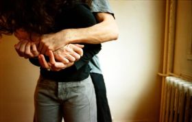 Man and woman embracing affectionately in a warmly lit room, representing the Managing Risk Minimising Restraint Online course.