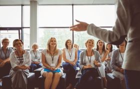 Woman discussing menopause with female colleagues, promoting Menopause Awareness as a natural phase in the workplace.