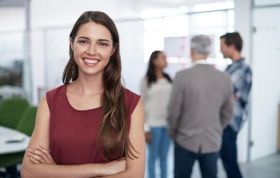 Smiling woman in a professional office setting, representing the Microsoft Access 2013 Course, showcasing a positive and welcoming atmosphere.
