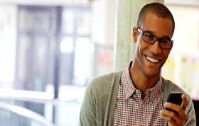 Smiling man holding cellphone, representing Microsoft Certified Azure Fundamentals course for technical and non-technical professionals.