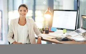 Cheerful woman seated at desk, suggesting a productive atmosphere, representing the Microsoft Word 2010 Course for document creation skills.