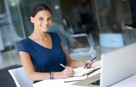 Cheerful woman in an office setting, representing the Microsoft Word 2013 Course, highlighting productivity and professionalism.