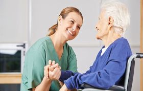 A nurse and elderly woman shake hands, symbolizing care, representing the Moving and Handling of People Online course.