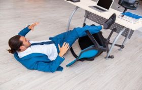 Man fallen from chair near desk, highlighting the importance of Office Safety for maintaining the safest work environment.