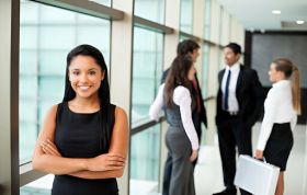 A woman in a business suit presents to an audience, representing the Oracle Database 12c Administration Online course.