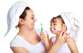 Mother and daughter brushing teeth together, promoting Oral Care for Children and supporting healthy tooth development habits.