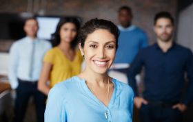 Smiling woman standing in front of a group, representing the Sage Computerised Accounting Level 3 course for advanced accounting skills.