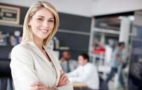 A smiling woman with colleagues, representing the Skillsfirst Award in Computerised Accounting for Business (Level 2) and basic understanding of bookkeeping.