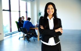 Woman in a business suit leads a discussion, representing the Skillsfirst Award in Computerised Sage Business Cloud Payroll for Business course.