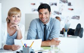 Man and woman seated at a desk, reviewing documents, representing the SQL Server 2008 Online course.