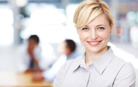 Smiling woman in front of a diverse group, representing SQL Training with Practice Labs course, highlighting collaboration and learning.