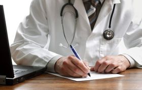 Doctor writing on paper, representing the Verification of Death course, focusing on supportive care and care homes.