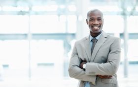 Confident man smiling while standing, representing Windows Server 2008 Active Directory Online Course for IT professionals.