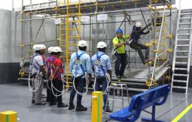 Group discussing construction plans and safety measures around scaffolding, representing the Working at Height Online course for safety training.