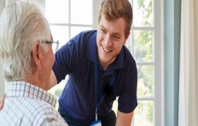 Smiling man in a blue shirt interacts with an older man, representing the Your Personal Development Online course for growth and self-improvement.